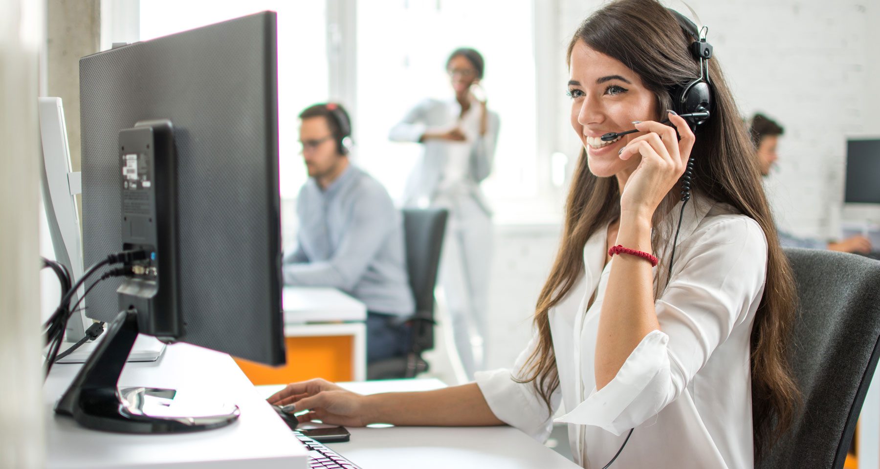 woman using a computer wearing a headset
