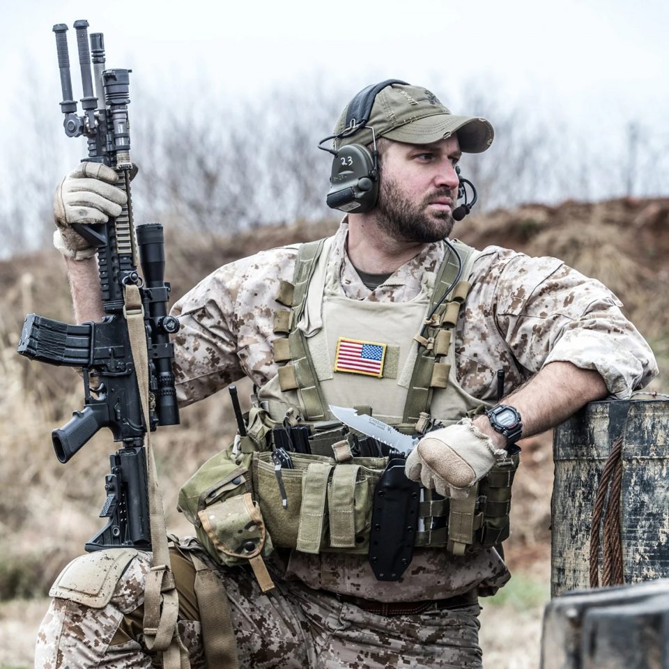 Man in tactical military gear with rifle and headset—representing values behind Blayzer’s WordPress solutions.