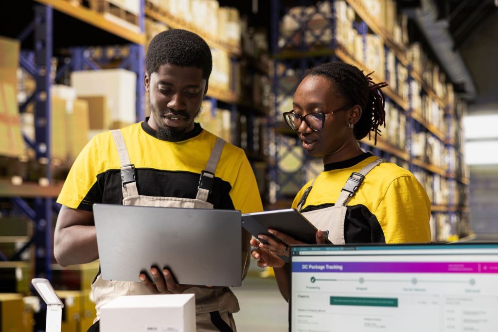 warehouse workers using computer to manage inventory