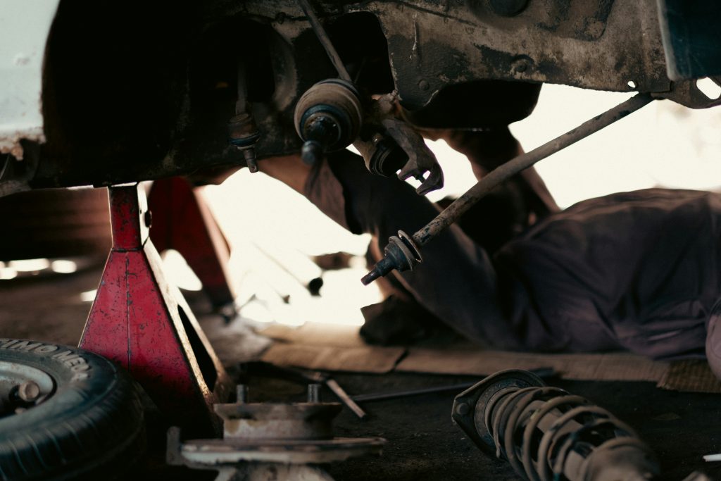 Mechanics working on vehicles in a busy automotive repair garage, representing parts and service that drive repeat purchases