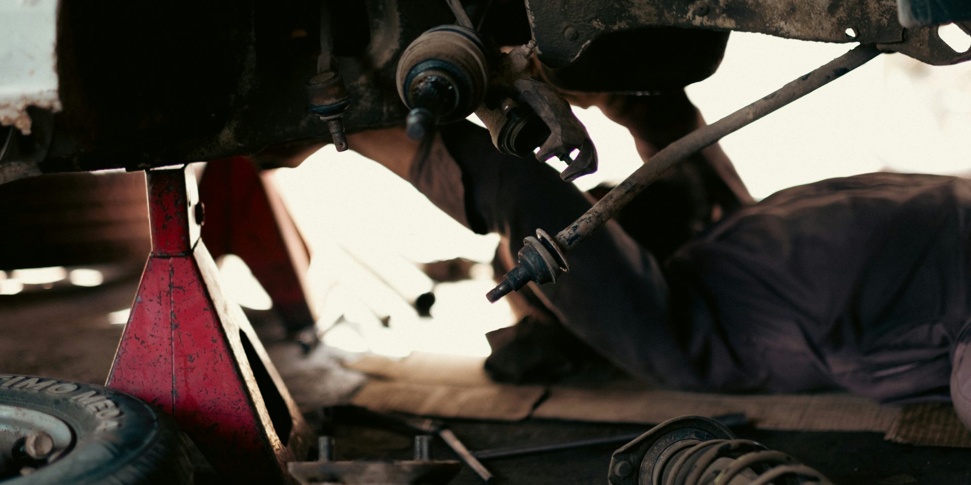 Mechanics working on vehicles in a busy automotive repair garage, representing parts and service that drive repeat purchases