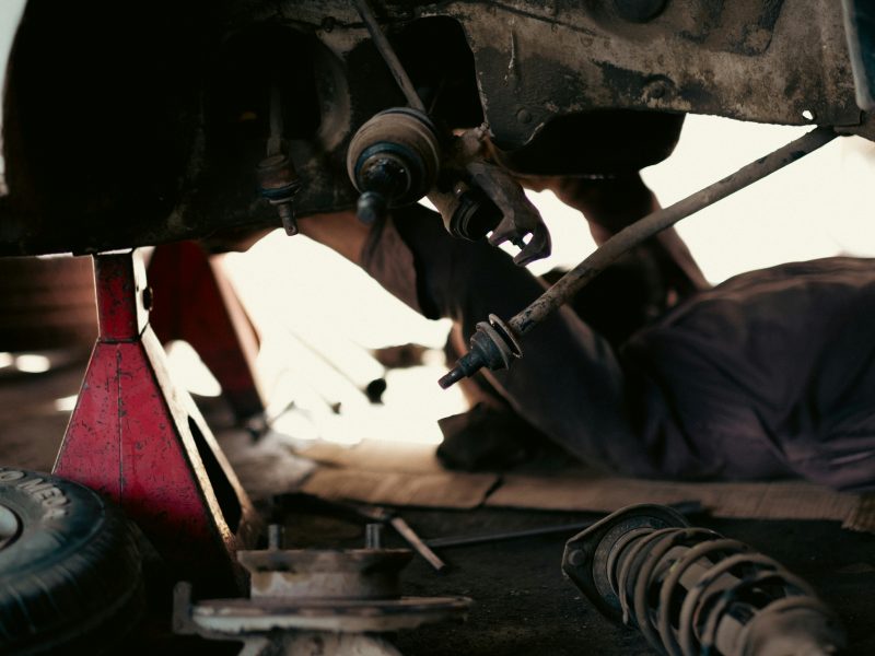 Mechanics working on vehicles in a busy automotive repair garage, representing parts and service that drive repeat purchases